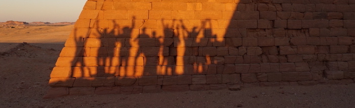 Schattenriss der Exkursionsteilnehmerinnen vor einer Pyramide am Jebel Barkal Slider.JPG